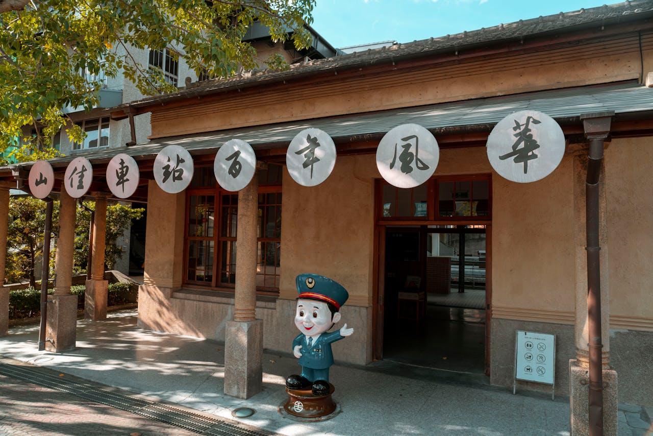 Charming historic train station with decorative lanterns and cartoon police statue.