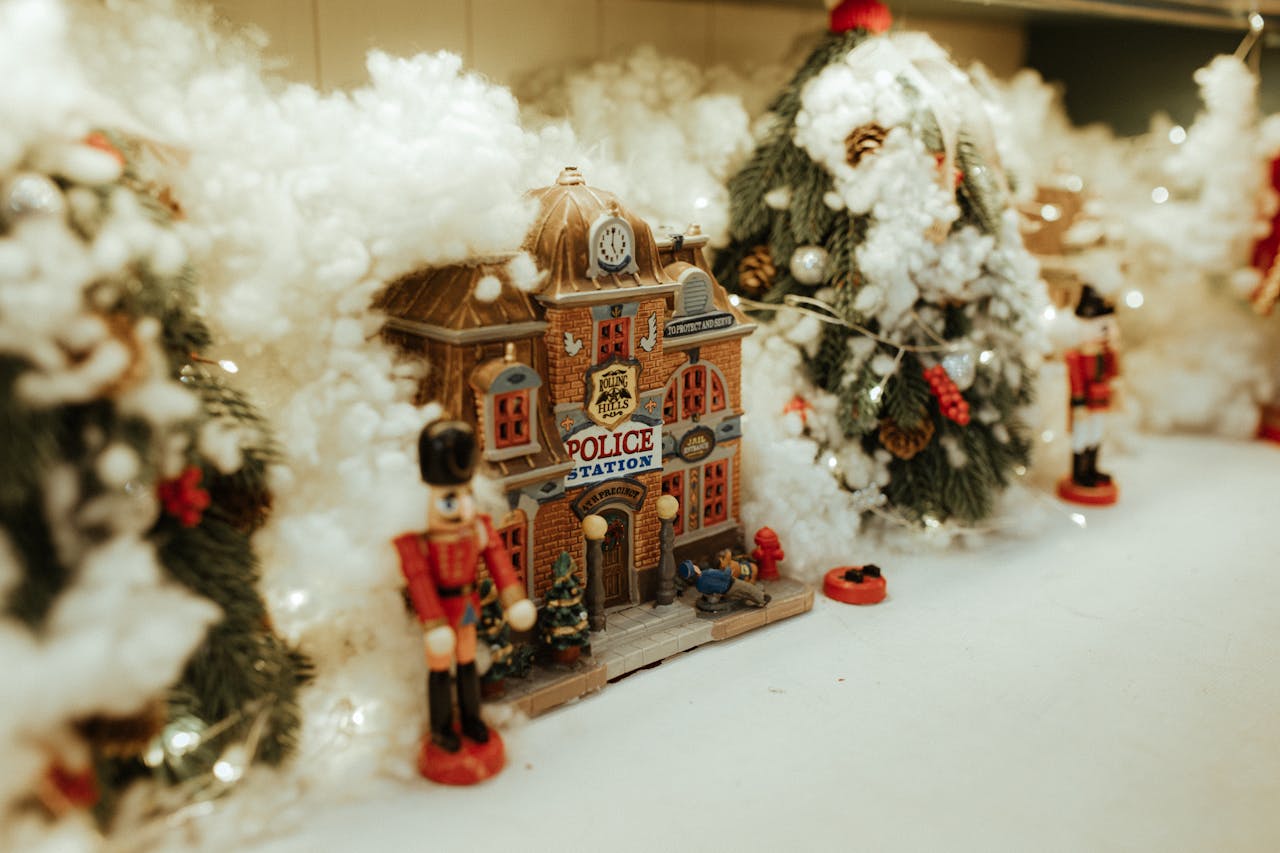 About Miniature Christmas village with snow and nutcracker, creating a festive scene.
